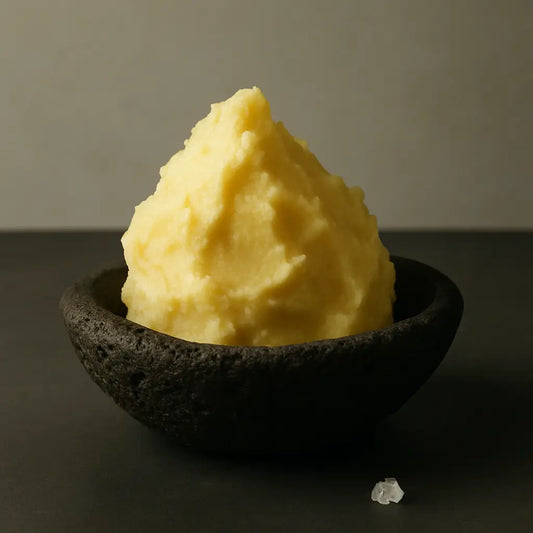 Wooden bowl of whipped shea butter with natural oils and soft lighting, symbolizing mindful skincare rituals and the calm of self-respect.