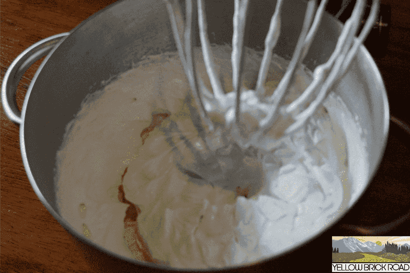Whipped Yellow Shea Butter in mixing bowl with whisk attachment, showcasing raw unrefined texture for deep skin and hair hydration.