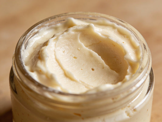 Unrefined shea butter in a wooden bowl with a spoon, styled for a beginner skincare blog.
